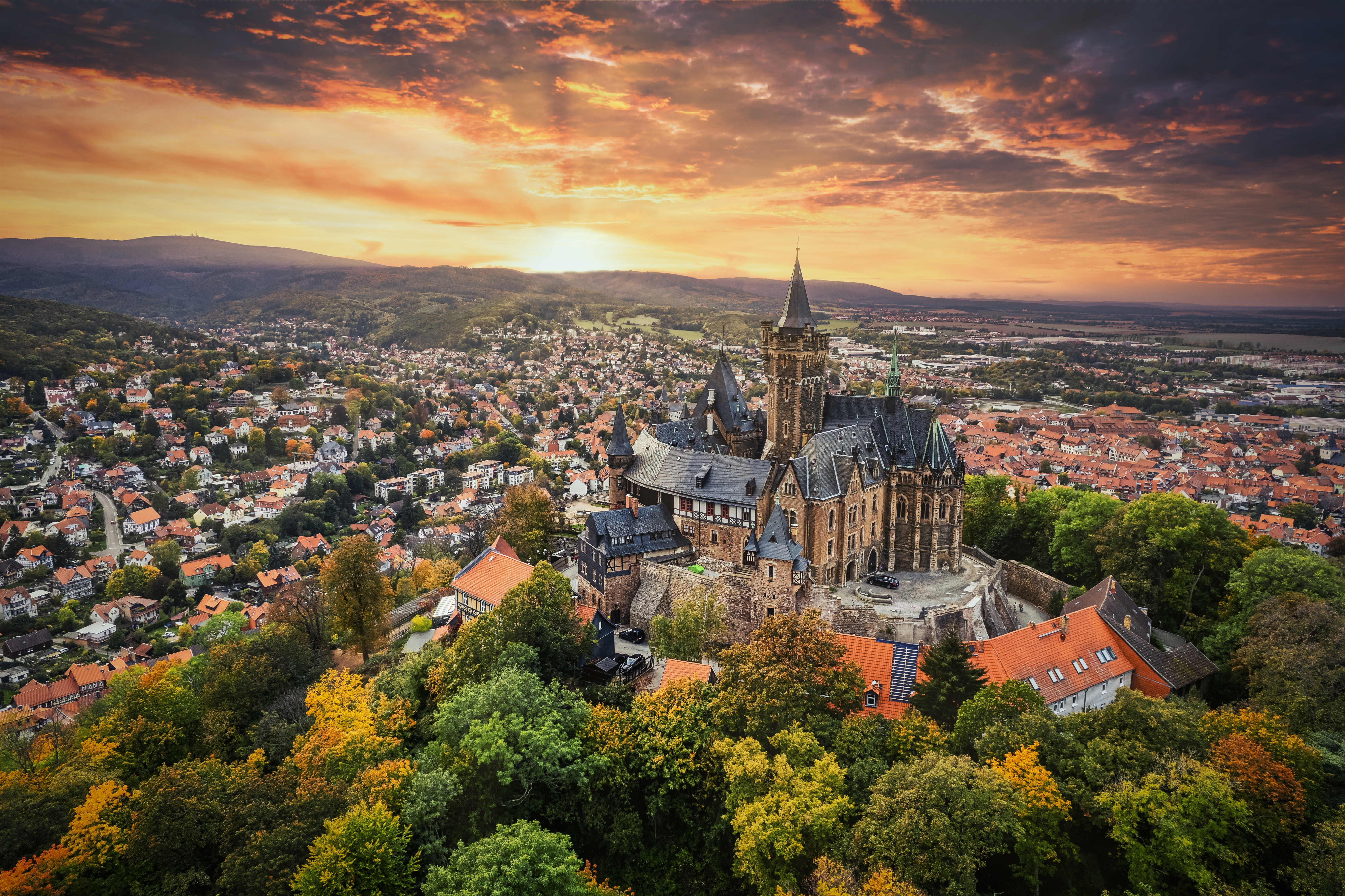Luftfoto af det historiske Wernigerode Slot med udsigt over den maleriske by i Harzen, Tyskland ved solnedgang