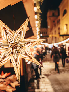 Stjerne-formet papirlanterne på julemarked i Wien om aftenen med traditionelle træboder