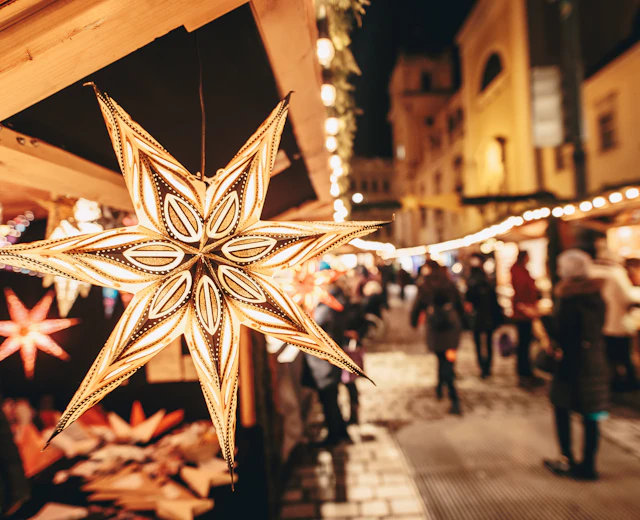 Stjerne-formet papirlanterne på julemarked i Wien om aftenen med traditionelle træboder