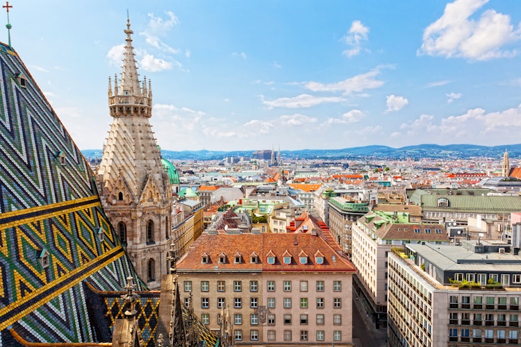 Betagende panoramaudsigt over Wiens historiske bycentrum med farverige tage og bygninger set fra Stephansdom-katedralens tårn på en solrig sommerdag