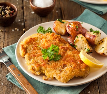 Klassisk wiener schnitzel med sprød panering serveret med stegte kartofler og citron, en ikonisk østrigsk specialitet der er et must at smage på rejsen til Wien