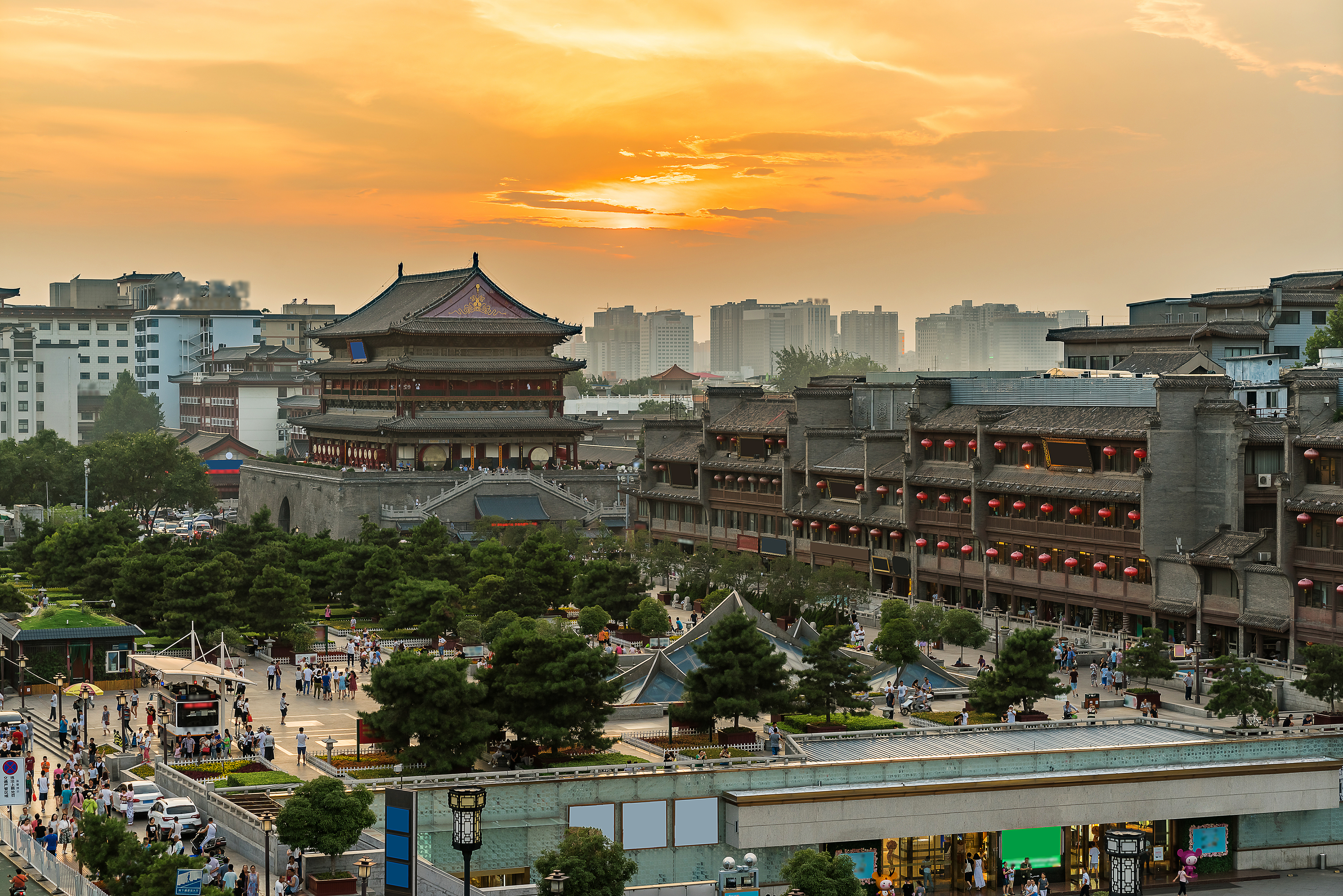 Traditionel kinesisk pagode og bymur ved solnedgang i Xian med gylden himmel