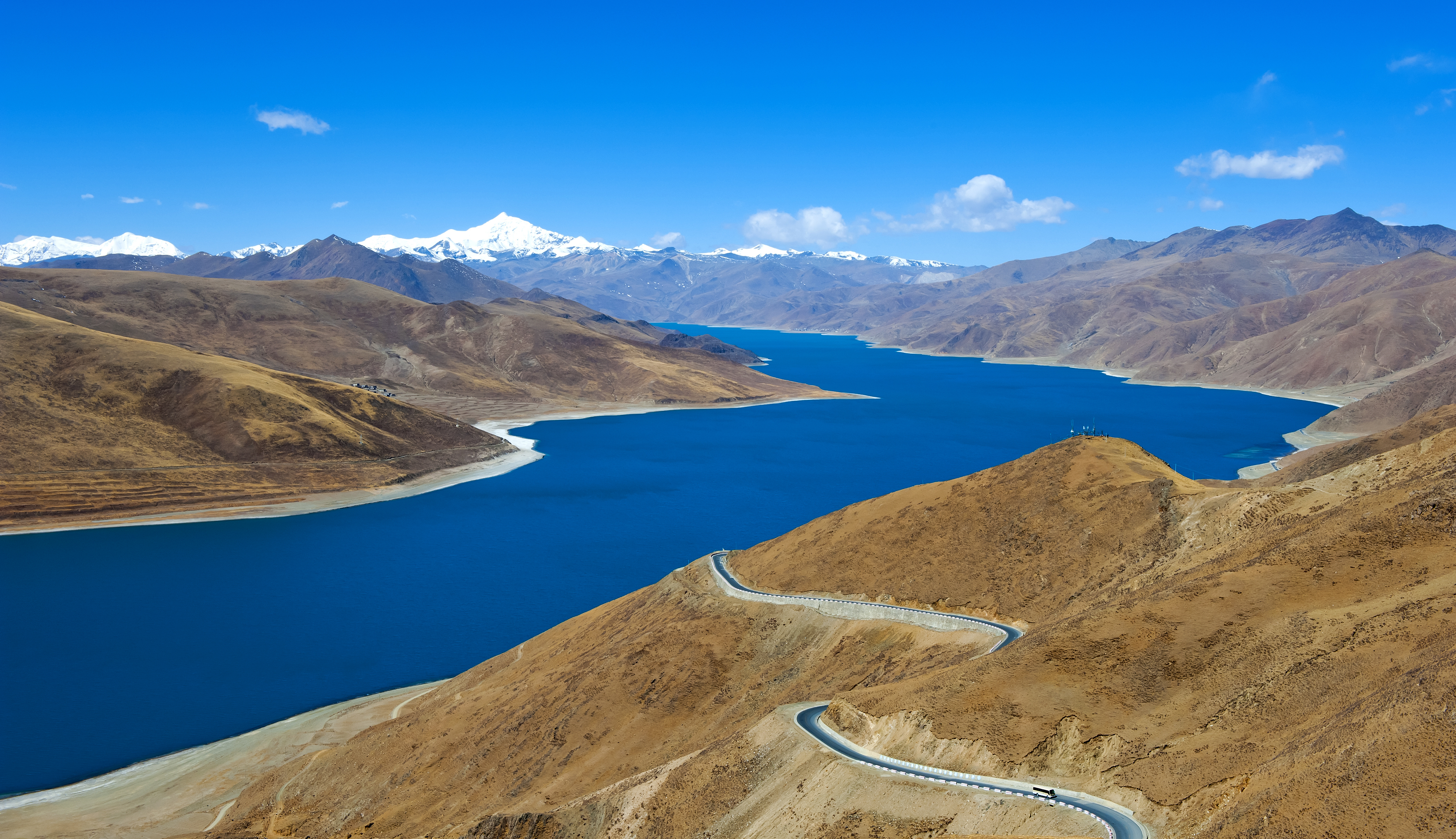 Fantastisk udsigt over turkisblå Yamdrok sø med snoet bjergvej gennem de tibetanske Himalayas