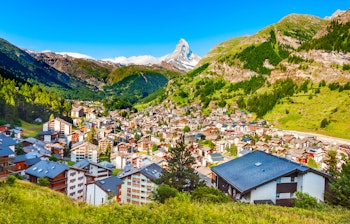 Panoramaudsigt over Zermatt by med traditionelle træhytter omgivet af de schweiziske alper og det ikoniske Matterhorn bjerg
