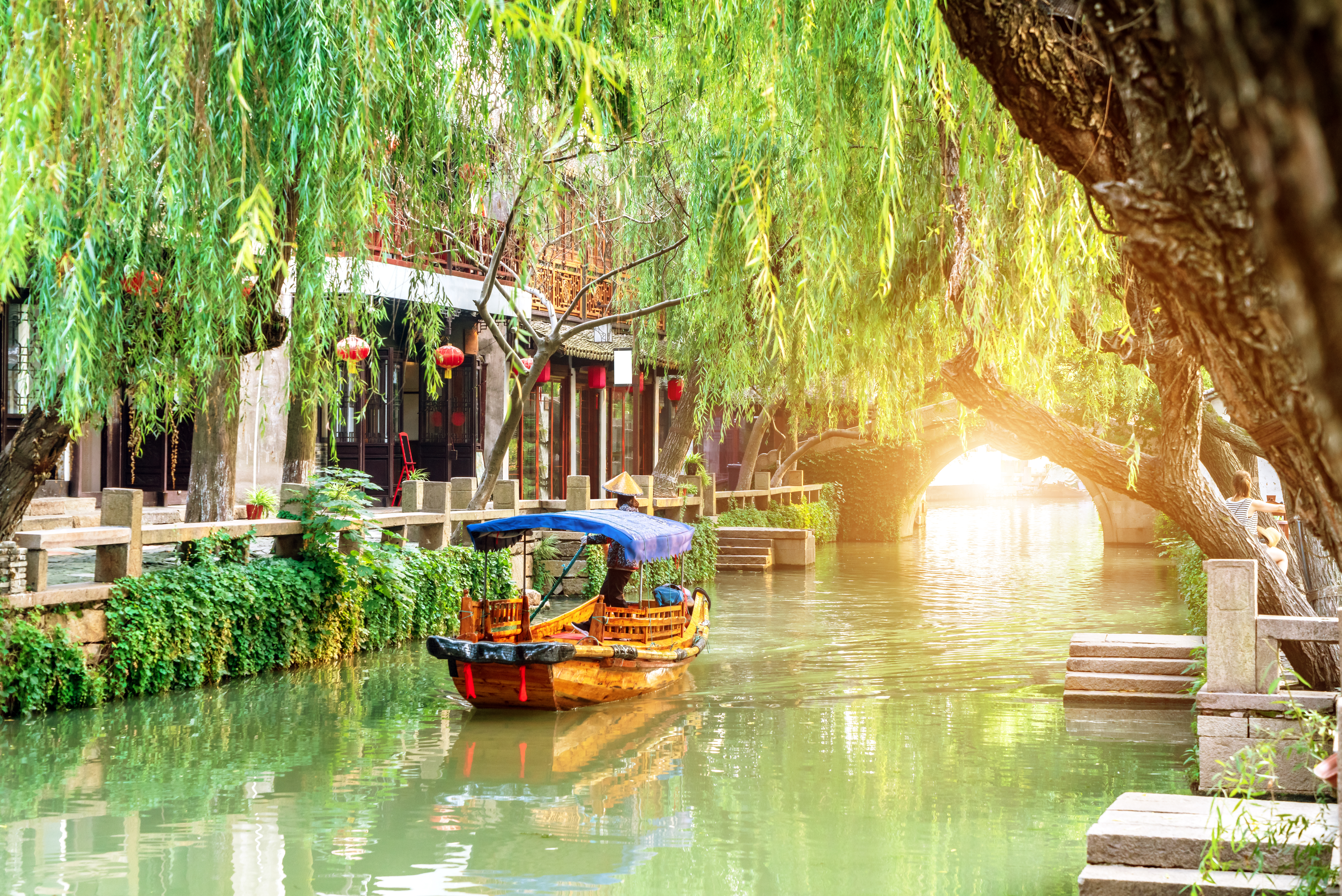 Traditionel kinesisk vandby Zhouzhuang med træbåde på fredelig kanal under piletræer